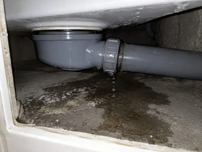 Avant : le siphon de la douche fuit à l'écrou, sous le receveur